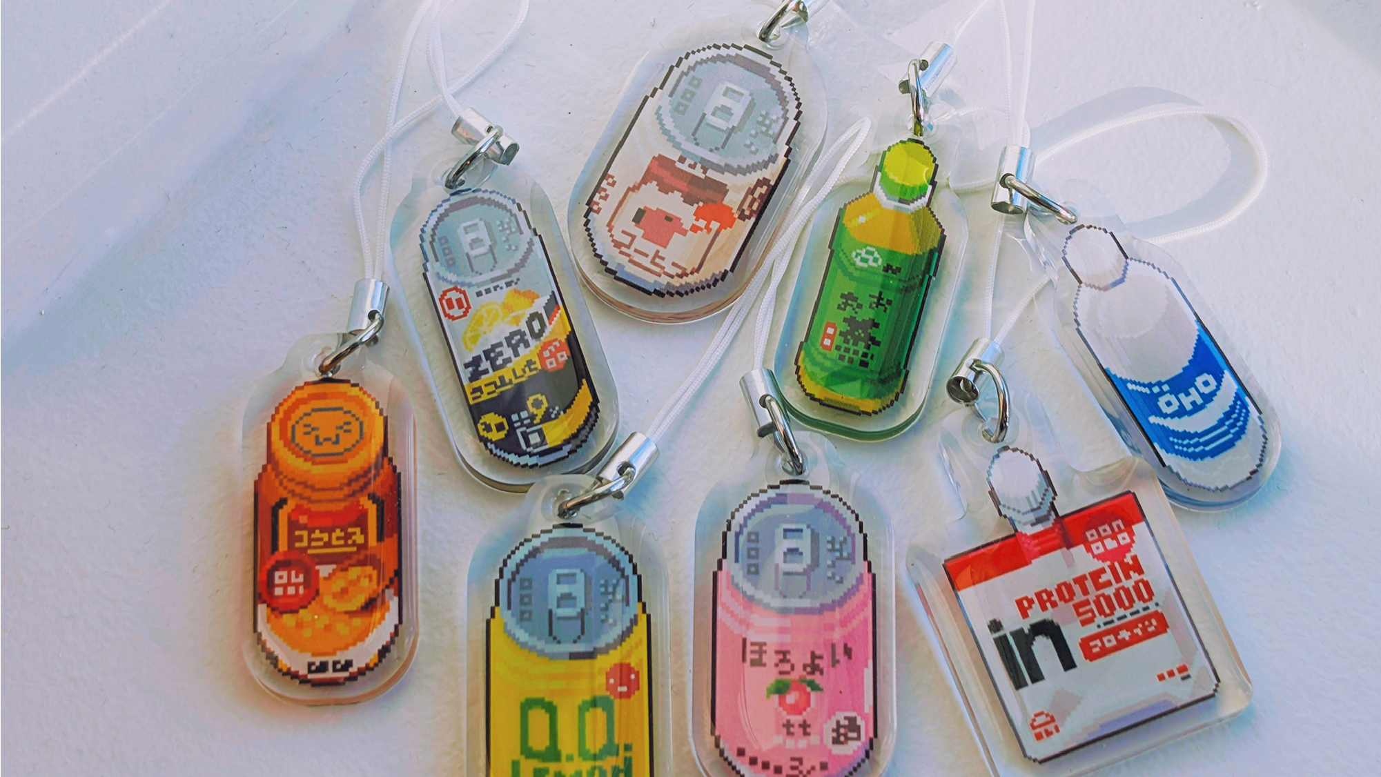 Phone strap acrylic charms with various designs on a white background